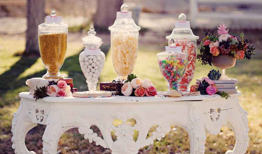 Sweet table na poroki. Lepa bela rustikalna miza na kateri so različni bomboni v lepih steklenih vazah. Foto: vir Weddings by Scott and Dana