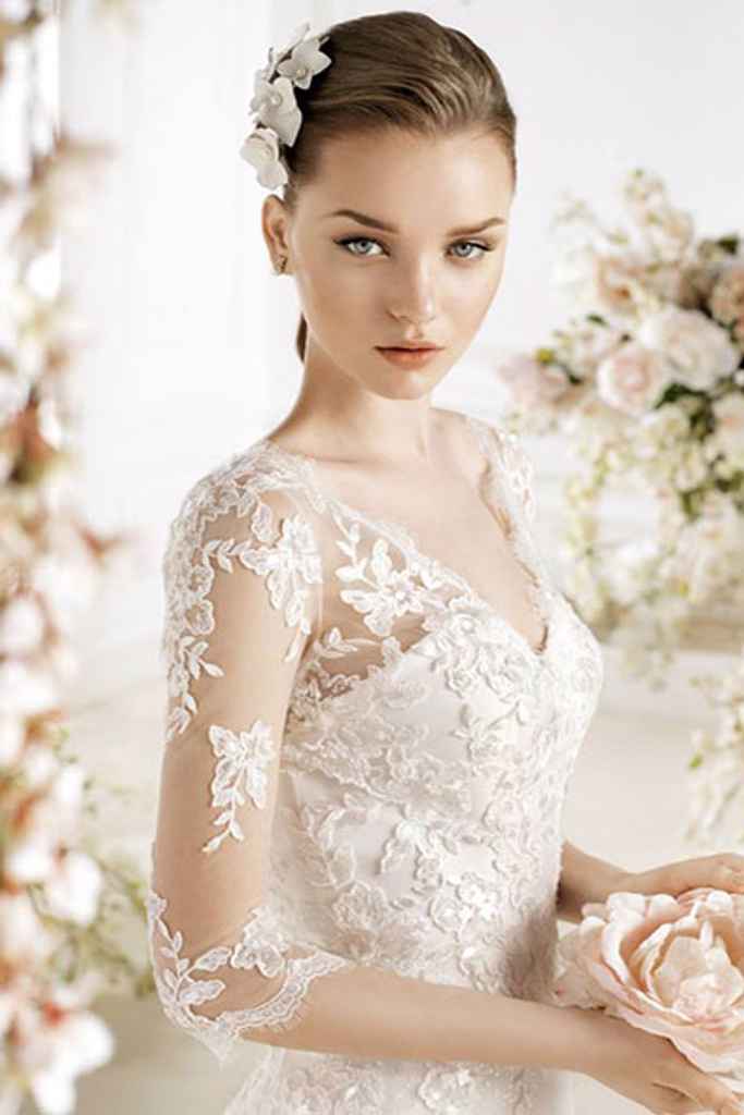 Nevesta v čipkasti poročni obleki z dolgimi čipkastimi rokavi. Foto: poročni salon Novias