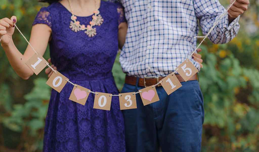Zaročenca držita v rokah napis z datumom njune poroke. Foto: vir Etsy - BannerCheer