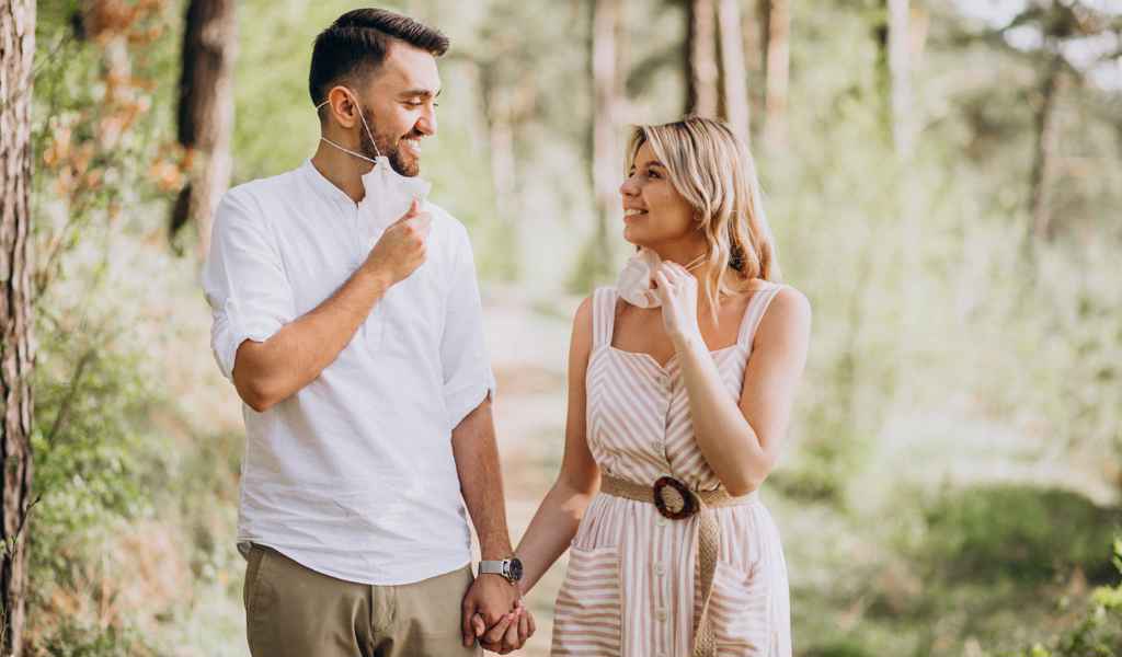 Par med načrtovanjem poroke na sprehodu v gozdu z masko. Foto: Storija weddings