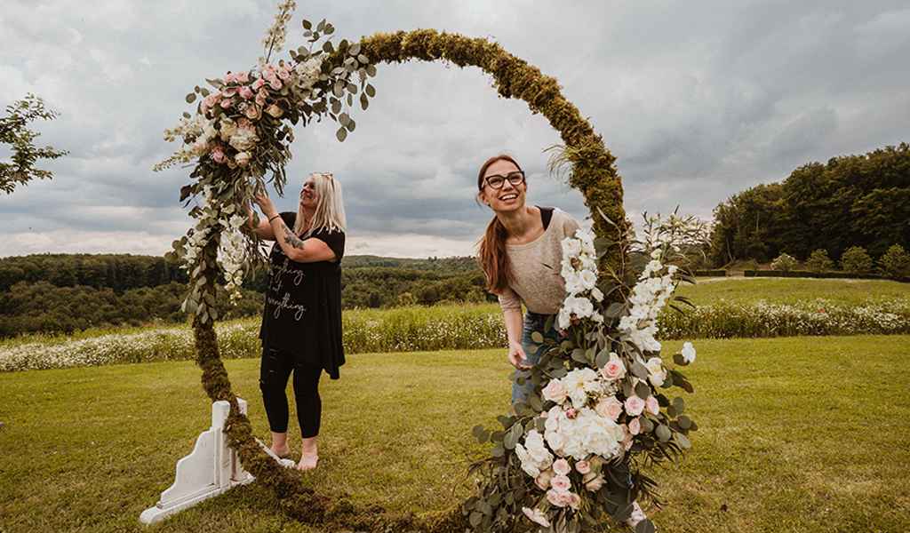 Organizacija poroke na Posestvu Pule, kjer organizatorka Petra Starbek v sodelovanji s priznanimi poročnimi ponudniki pripravlja prekrasen okrogel cvetlični obok.